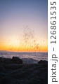 Waves crashing on rocks at sunset creating stunning water droplets 126861535