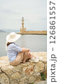 Tourist admiring chania lighthouse from venetian harbor wall in crete 126861557
