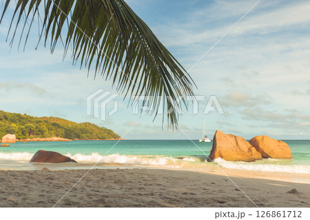 Beautiful tropical beach featuring soft sandy shores, turquoise waves Beautiful tropical beach featuring soft sandy shores, turquoise waves 126861712