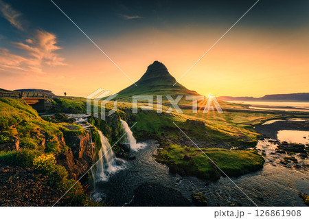 Sunrise over Kirkjufell mountain with waterfall flowing on moss field during summer at Iceland 126861908