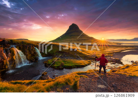 Colorful majestic sunrise over Kirkjufell mountain with photographer standing in autumn at Iceland 126861909