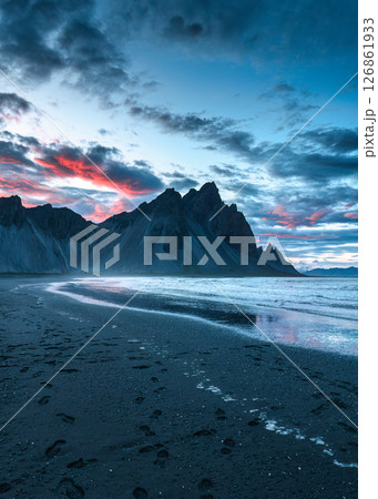 Sunset over volcanic Vestrahorn mountain on black sand beach in summer at Iceland 126861933
