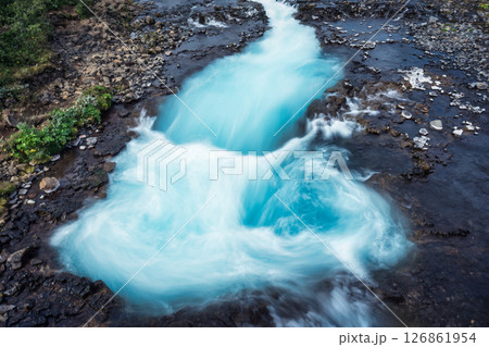 Turquoise Bruarfoss waterfall flowing rapidly over wilderness 126861954