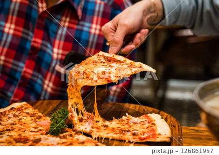 Delicious cheese meat pizza with stretchy melted cheese on wooden plate 126861957