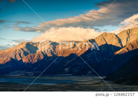 Golden sunrise over rugged rocky mountain range in autumn at New Zealand Golden sunrise over rugged rocky mountain range in autumn at New Zealand 126862157