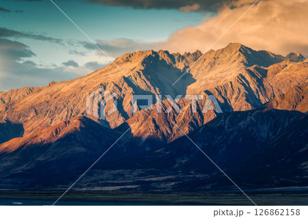 Golden sunrise over rugged rocky mountain range in autumn at New Zealand Golden sunrise over rugged rocky mountain range in autumn at New Zealand 126862158