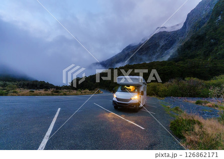 Motorhome parked along quiet road surrounded by misty mountain in rainforest national park 126862171