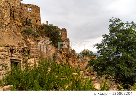 Dagestan Gamsutl. Ancient ghost town of Gamsutl old stone houses in abandoned Gamsutl mountain village in Dagestan, Abandoned etnic aul, summer landscape. 126862204