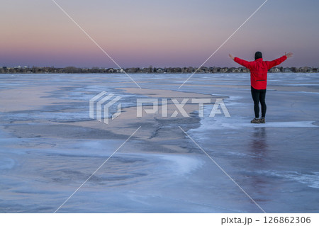 lonely male figure on a frozen lake at dusk in Colorado - Boyd Lake State Park lonely male figure on a frozen lake at dusk in Colorado - Boyd Lake State Park 126862306