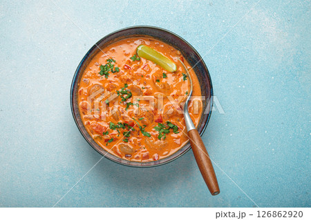 Brazilian traditional dish moqueca de camarao with shrimps, lime, peppers, and cilantro is served in a bowl on light blue background top view 126862920