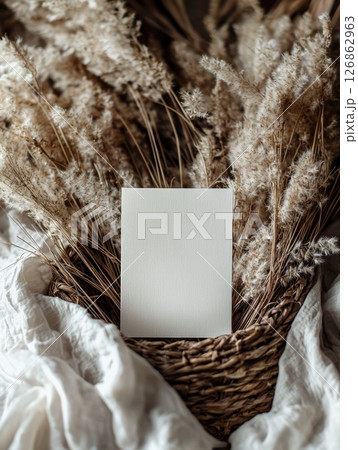 Blank A5 card on dried pampas grass in rustic basket 126862963