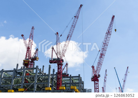 Low-angle view of cranes and steel structures of building construction with a blue sky background in Taiwan. 126863052