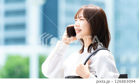 スマートフォンで話す笑顔の女性・ビジネスウーマン 126863094