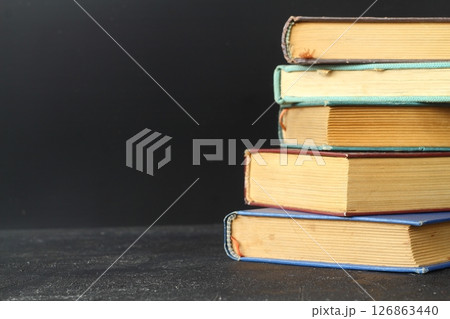 Close-up of stack of old used books background. Pile of vintage old hardback books. Back to school 126863440