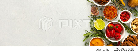 A mix of dried herbs and spices laid out on a gray background, highlighting natural flavors and culinary essentials, top view and copy space, banner A mix of dried herbs and spices laid out on a gray background, highlighting natural flavors and culinary essentials, top view and copy space, banner 126863619