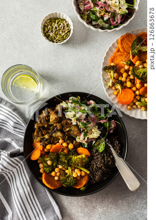 A balanced breakfast bowl with black quinoa, avocado, roast chicken, and sweet potatoes, topped with a fresh cabbage and radish salad 126863678
