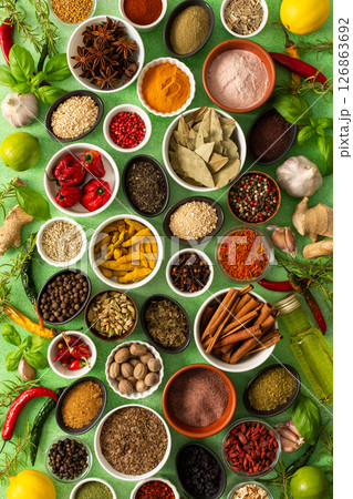 Brightly colored spices and herbs arranged on a delicate green background, highlighting their freshness and fragrance for a lively, natural look Brightly colored spices and herbs arranged on a delicate green background, highlighting their freshness and fragrance for a lively, natural look 126863692