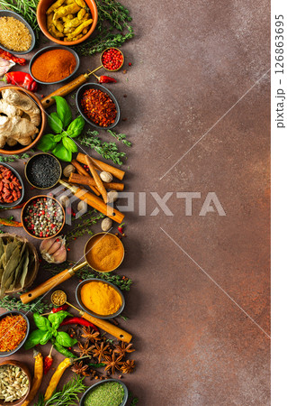 A harmonious mix of spices and herbs, bursting with colors and fragrances, spread on a warm brown background, evoking a sense of culinary artistry A harmonious mix of spices and herbs, bursting with colors and fragrances, spread on a warm brown background, evoking a sense of culinary artistry 126863695