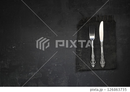 Overhead shot of silverware on black table with copy space. 126863735