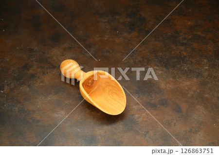 Top view of empty wooden scoop isolated on a rusty background. Top view of empty wooden scoop isolated on a rusty background. 126863751