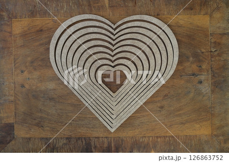 Wooden heart shaped picture frame isolated on wooden background 126863752