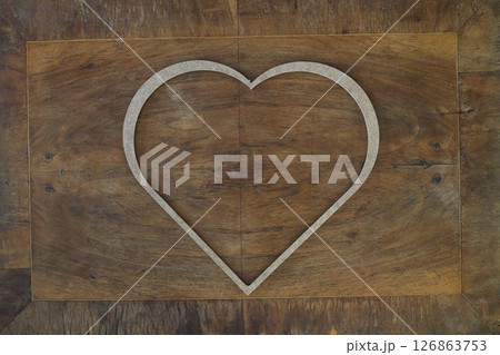 Wooden heart shaped picture frame isolated on wooden background 126863753