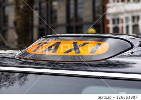 Classic London Black Taxi Roof Sign, Iconic Orange TAXI Sign on Traditional Cab 126863987