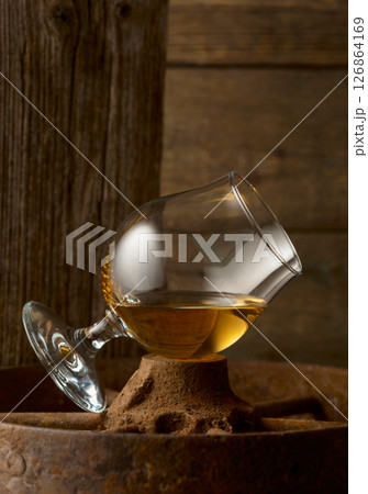 Cognac in snifter on old rusty wheel. Cognac in snifter on old rusty wheel. 126864169