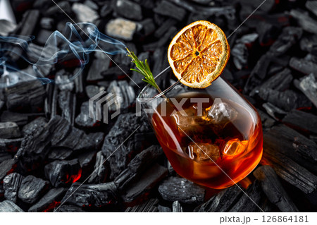 Old-fashioned cocktail with ice, dried orange slice, and rosemary. Old-fashioned cocktail with ice, dried orange slice, and rosemary. 126864181