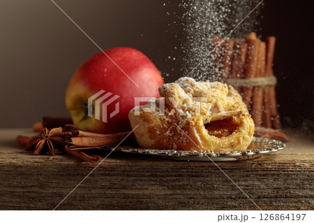 Viennese strudel with apple and cinnamon on old wooden table. Viennese strudel with apple and cinnamon on old wooden table. 126864197