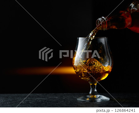 Brandy being poured into a glass. Brandy being poured into a glass. 126864241