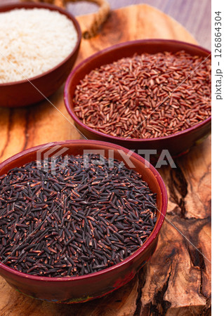 set of red and black and white rice, in a bowl, on a wooden surface, rustic style, top view set of red and black and white rice, in a bowl, on a wooden surface, rustic style, top view 126864304