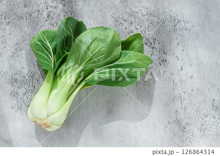 Fresh bok choy, laid out on a light gray surface, top view, natural light, 126864314
