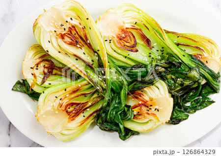 Grilled bok choy served with soy sauce and sesame seeds, on a white plate, homemade, no people, 126864329