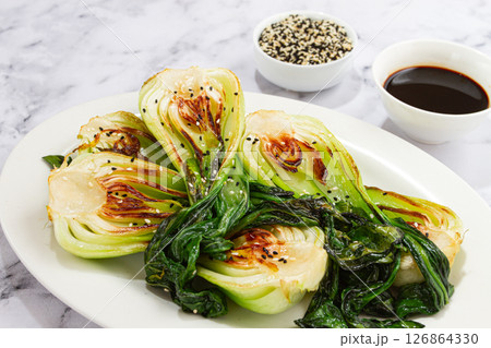 Grilled bok choy served with soy sauce and sesame seeds, on a white plate, homemade, no people, 126864330
