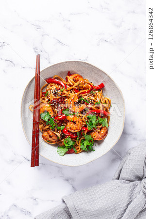 udon noodles, shrimp with vegetables and fresh herbs, in a bowl with chopsticks, light background, homemade, no people, 126864342
