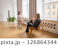 session with a psychologist. a female psychologist listens attentively to a female client in a large bright office. 126864344