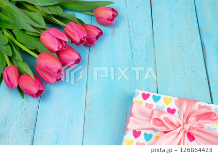 Bouquet of tulips on blue wooden table with gift box. Happy women's day. 8 March., Mother's Day. Flat lay and copy space 126864428