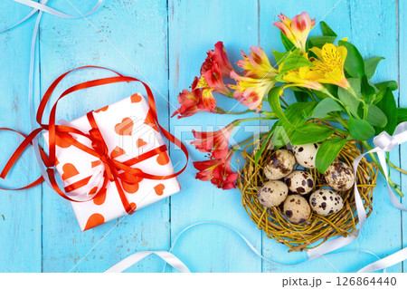 Spring background. Bouquet of flowers on a wooden background and a nest with eggs. spring Spring background. Bouquet of flowers on a wooden background and a nest with eggs. spring 126864440
