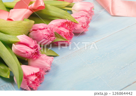Bouquet of tulips on blue wooden table. Happy women's day. 8 March., Mother's Day. Flat lay and copy space Bouquet of tulips on blue wooden table. Happy women's day. 8 March., Mother's Day. Flat lay and copy space 126864442