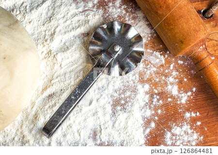 forms for squeezing the dough. dough on the table with dough tools. 126864481