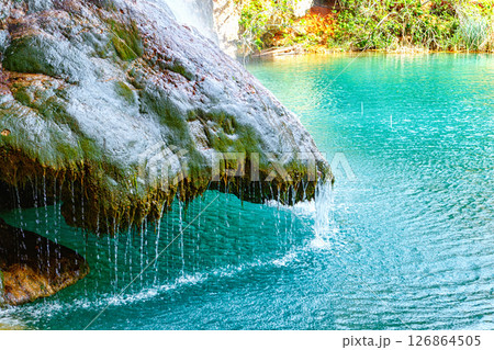 Adventurers Rappel Down a Stunning Waterfall in a Rocky Landscape Surrounded by Lush Greenery 126864505