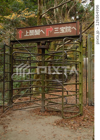 山道の分岐点にある回転ゲートと案内標識 126864996