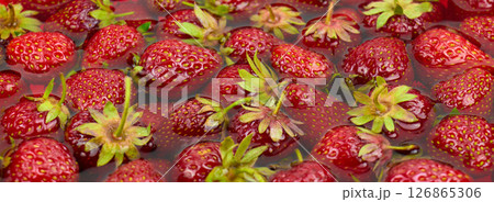 Juicy red strawberries are submerged in clear water, showcasing their freshness 126865306