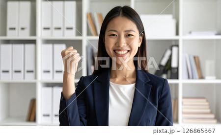 笑顔でガッツポーズする女性社員 126865367