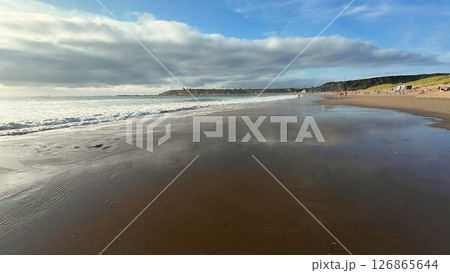 Experience a Serene and Tranquil Beach Scene with Calm Waves and a Scenic, Bright Sky Experience a Serene and Tranquil Beach Scene with Calm Waves and a Scenic, Bright Sky 126865644