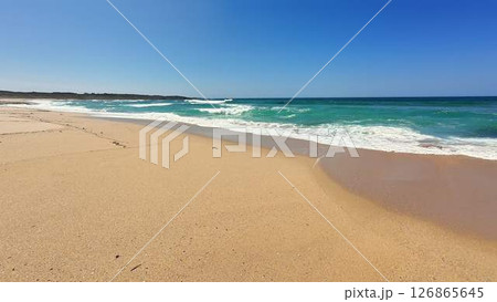 A Beautiful and Peaceful Beach Landscape Featuring Clear Blue Waters and a Sandy Shoreline 126865645