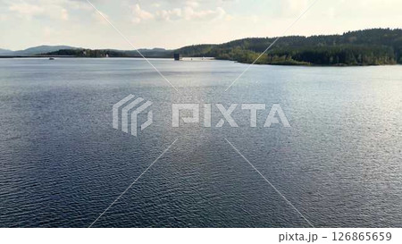The Serene Waters of a Tranquil Lake are beautifully accompanied by Lush Surroundings all around The Serene Waters of a Tranquil Lake are beautifully accompanied by Lush Surroundings all around 126865659