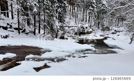 Explore the enchanting Winter Wonderland A Beautifully Serene Scenic Snowy River Scene Awaits You 126865669