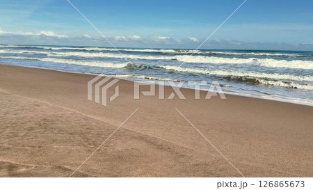 A Tranquil and Peaceful Beach Scene Featuring Gentle Waves and Soft, Warm Sand Beneath Your Feet 126865673